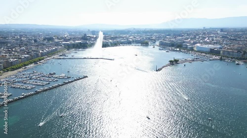 Aerial view of the Jet d'Eau de Genève, with boats sailing on the shimmering water and the city skyline in the distance, Genève, Switzerland.