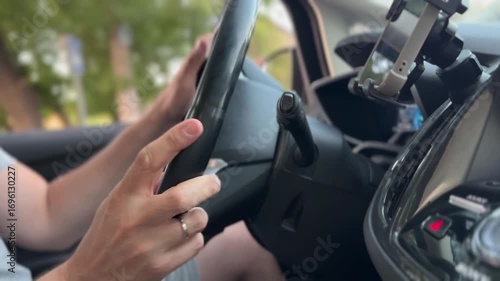 Man driving car. hand on the steering wheel against the background of the road on sunny day