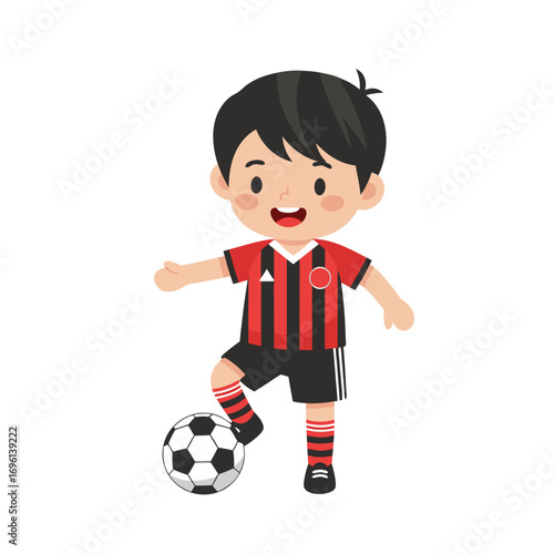 Cheerful child athlete in a red and black uniform practicing with a classic soccer ball