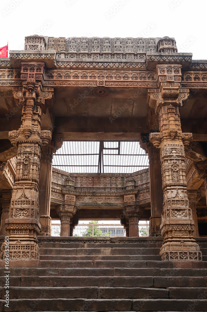 Obraz premium Beautiful Intricate Carvings on the Pillars and Wall of Adalaj Stepwell, 14th Century Vaghela Dynasty Monument. Adalaj, Gandhinagar, Gujarat, India.