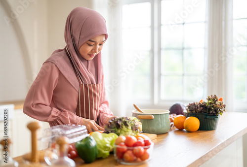 Muslim woman wearing hijab preparing fresh vegetables and fruits in kitchen, healthy lifestyle clean eating cooking, wellness and tradition, nutrition family care, vitamins supplement, halal cooking
