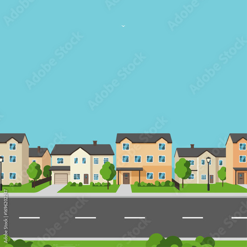 A row of suburban houses with manicured lawns and a paved road in front under a clear blue sky.
