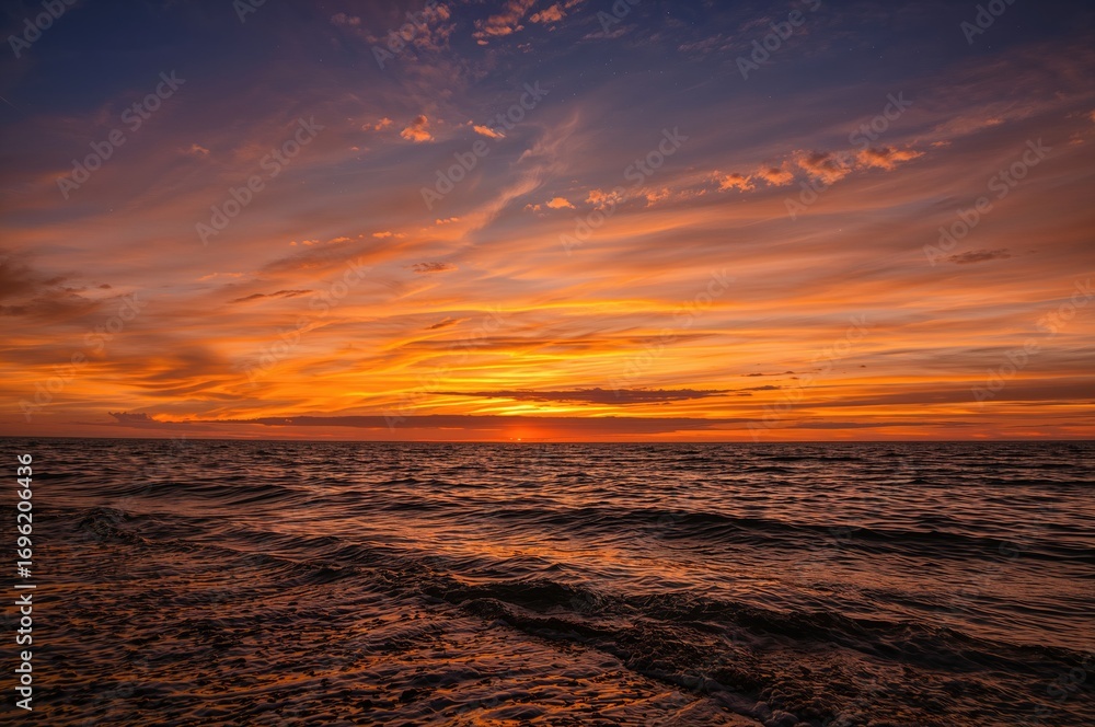 Fototapeta premium As daylight fades, golden and red tones light up the sky, painting a stunning sunset that celebrates the splendor of the natural world.