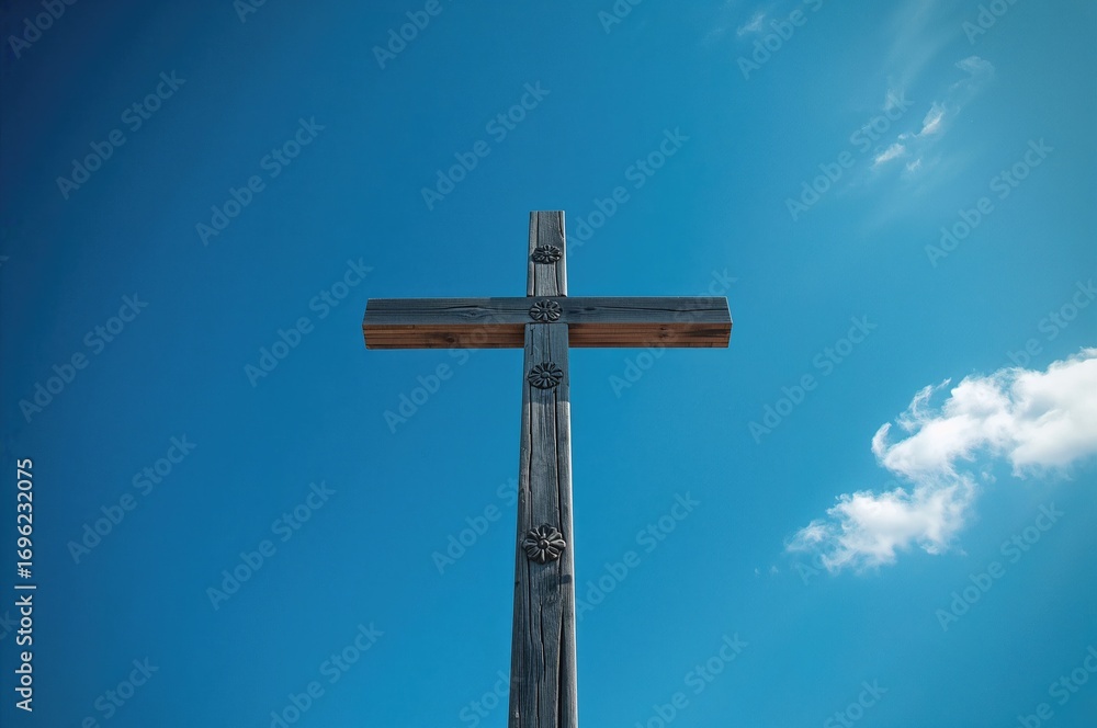 A tall wooden cross set against a bright blue sky A tall wooden cross set against a bright blue sky