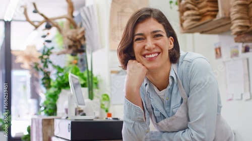 Portrait Of Smiling Female Sales Assistant Leaning On Sales Desk Of Florists Store