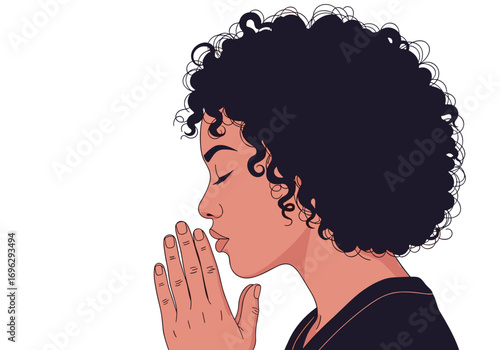 A young black woman with curly hair clasps her hands together in prayer with her eyes closed in quiet contemplation