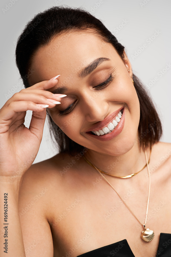 Fototapeta premium Stylish young woman poses gracefully in a chic black outfit in a modern studio space