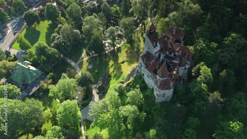 Aerial top view of Bran Castle in Romania with interior courtyard and surrounding village on a bright summer morning