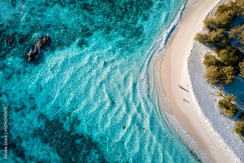 Stunning aerial view of turquoise waters, white sand beach, and lush green shoreline