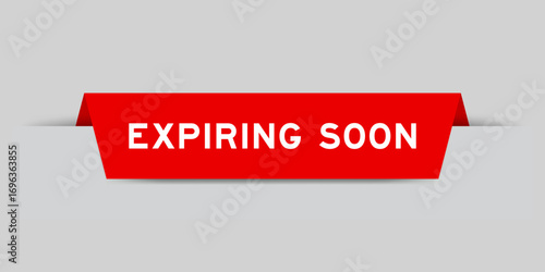 Red color inserted label with word expiring soon on gray background