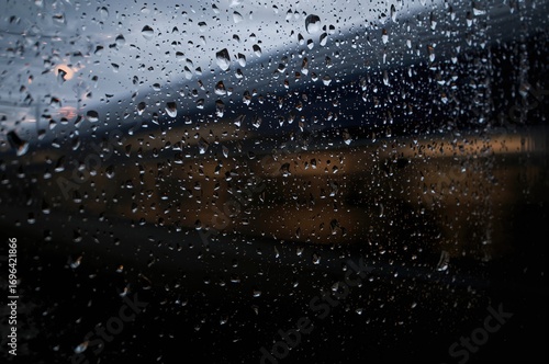 Raindrops cling to the glas...
