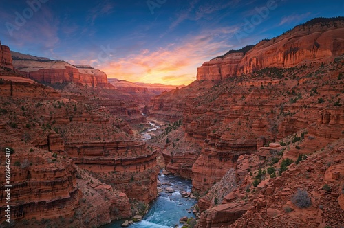 A flowing river carves through a valley lined with massive crimson stones as the sun sets over the gorge. Majestic wilderness panorama showcasing the canyon's untouched environment. A glimpse of the