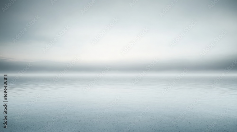 Fototapeta premium A serene landscape featuring calm waters and a soft, misty horizon, creating a tranquil and minimalist atmosphere.