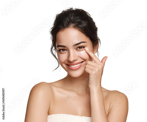 Radiant young woman gently applying eye cream to rejuvenate delicate skin under eyes demonstrating beauty routine for skincare and wellness against a minimal aesthetic backdrop