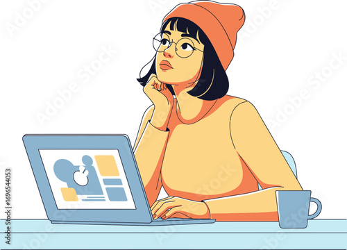 A creative young woman in a beanie and glasses is sitting at her desk with a laptop, looking up and thinking about a new project or idea