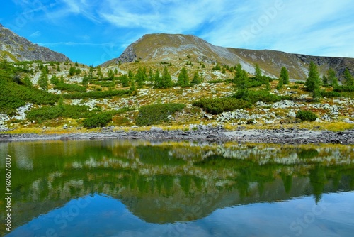 Rosennock mountain peak above Naßbodensee lake with a reflection in the water in Nock mountains and Gurktal alps in Carinthia, Austria