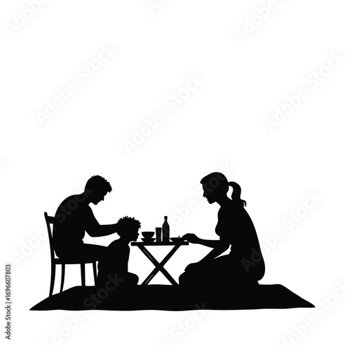 Family picnic silhouette with a child and parents at a table