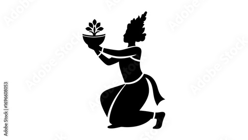 silhouette of a Balinese dancer kneeling gracefully while holding an offering bowl