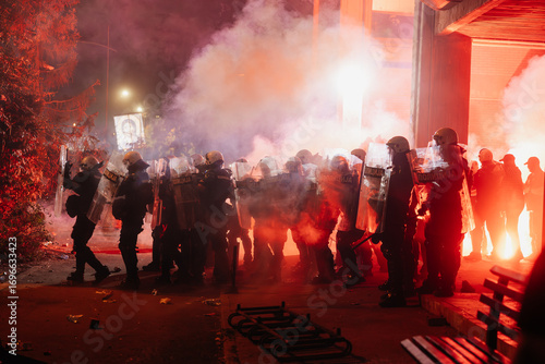 Protestors face police in a tense standoff during a nighttime demonstration in an urban area