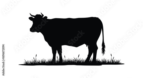 a black silhouette of a cow standing on grass