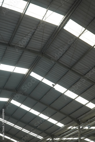 Bilde på lerret Industrial warehouse roof structure with metal beams and skylight panels allowing natural light inside