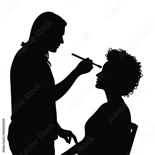 Makeup artist applying makeup to woman's face silhouette