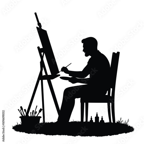 Silhouette of a man painting on an easel artist canvas
