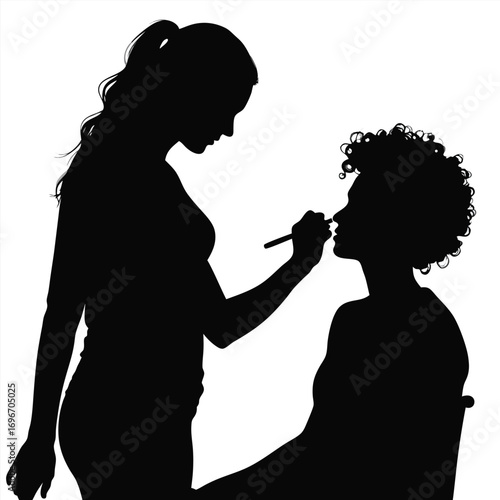 Silhouette of makeup artist applying makeup to client Keywords: silhouette, makeup artist