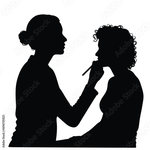 Silhouette of makeup artist applying makeup to client Keywords: silhouette, makeup artist