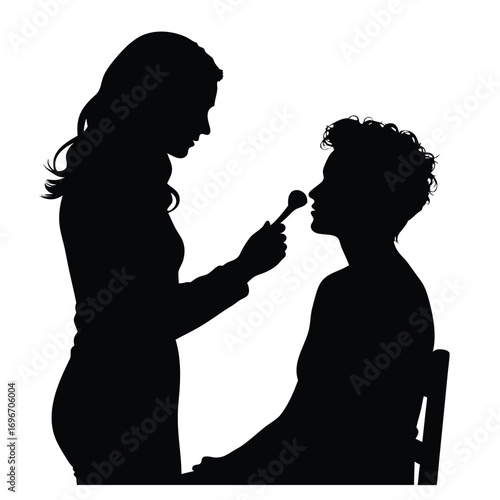 Silhouette of makeup artist applying makeup to client
