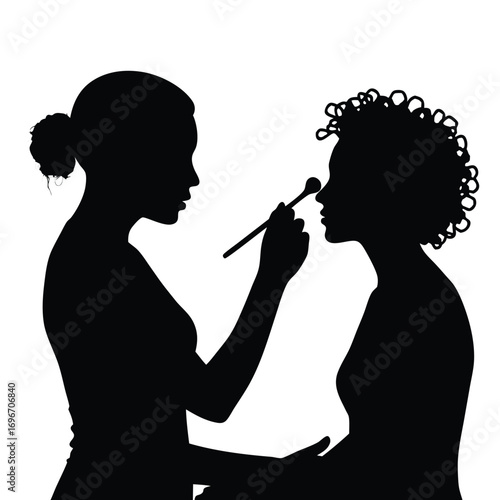 Silhouette of makeup artist applying makeup to client
