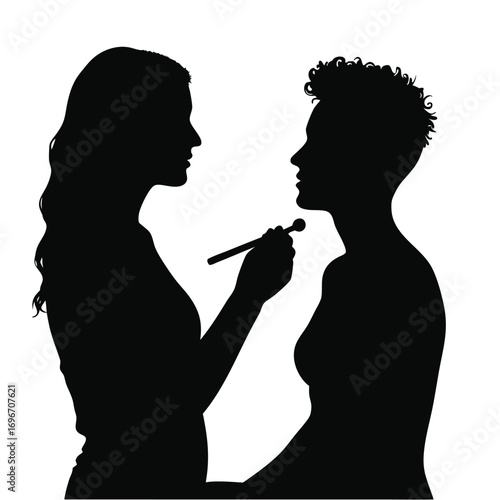 Silhouette of makeup artist applying makeup to person