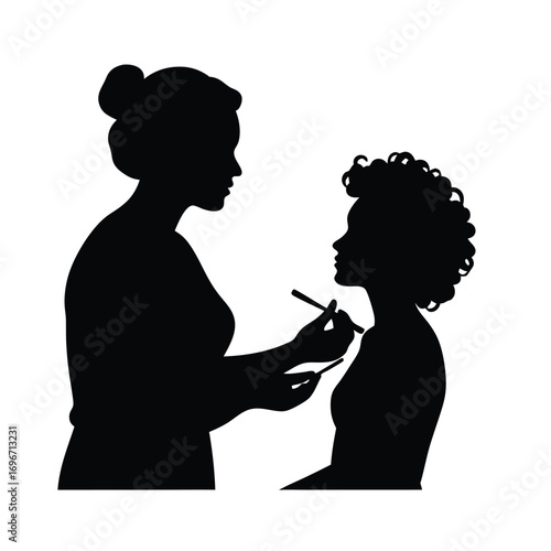 Silhouette of makeup artist with hair bun applying makeup