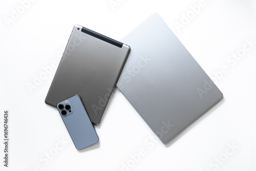 Silver laptop with tablet and mobile phone - high tech gadgets on white background, top view
