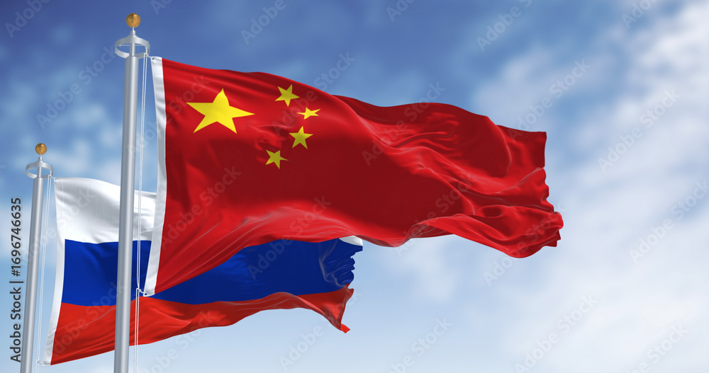 Naklejka premium The flags of China and Russia waving in the wind on a clear day