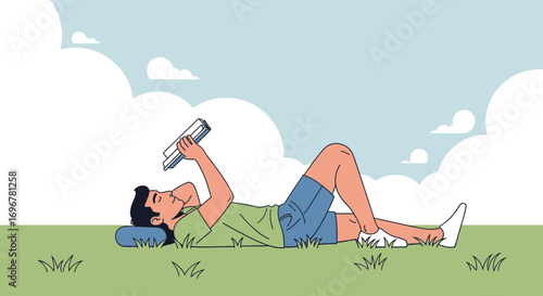 Man Reading Book Outdoors While Reclining on the Grass Under A Blue Sky With Clouds