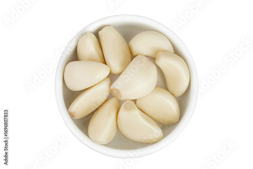 garlic cloves in ceramic bowl isolated on white background close up. Top view. Flat lay.