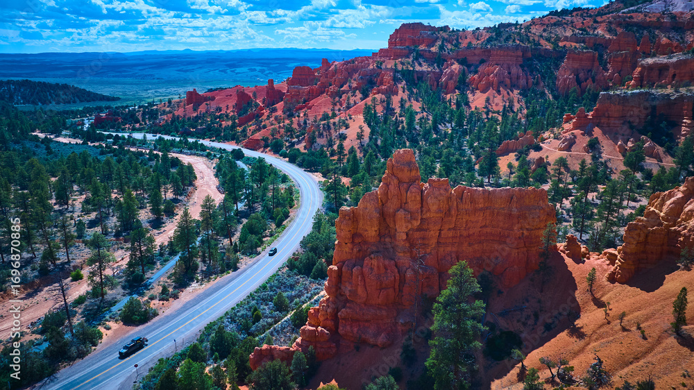 Obraz premium Aerial Red Canyon Road and Red Rock Formations with Pine Trees Utah