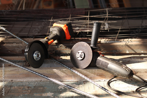 Two angle grinders close-up. Cordless and corded angle grinders, power tools for construction and repair work. Tools close-up. Repair work in the country. Grinders with metal discs