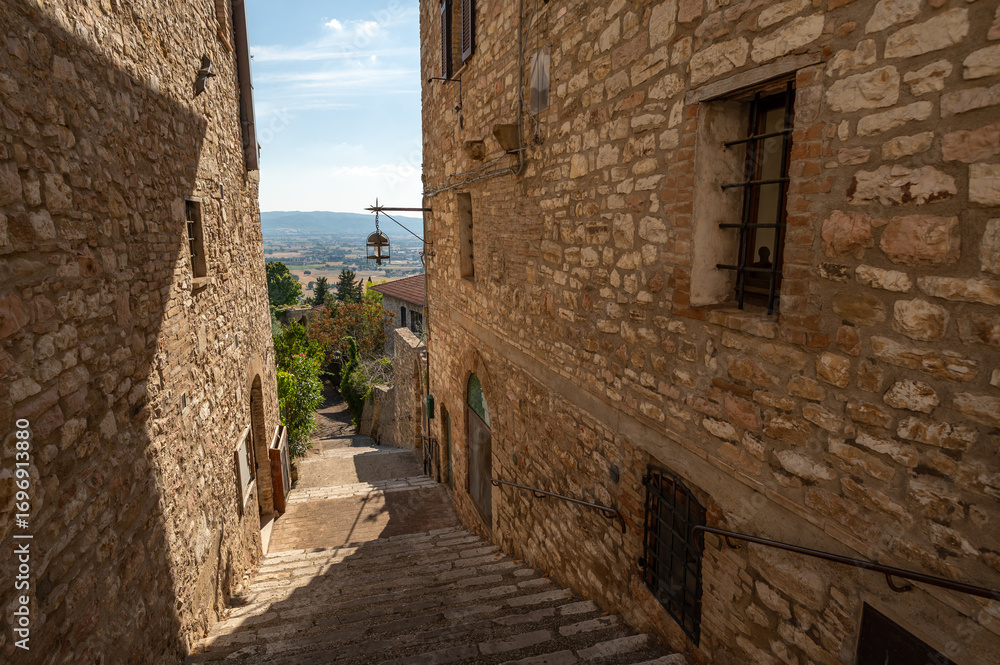 Naklejka premium Beautiful Tuscan historical street and place in the city of Assisi, Tuscany, Italy, Europe. Medieval atmosphere