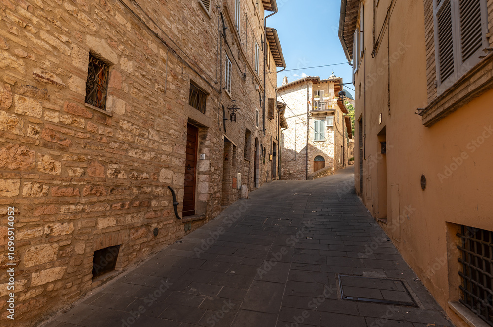 Naklejka premium Beautiful Tuscan historical street and place in the city of Assisi, Tuscany, Italy, Europe. Medieval atmosphere