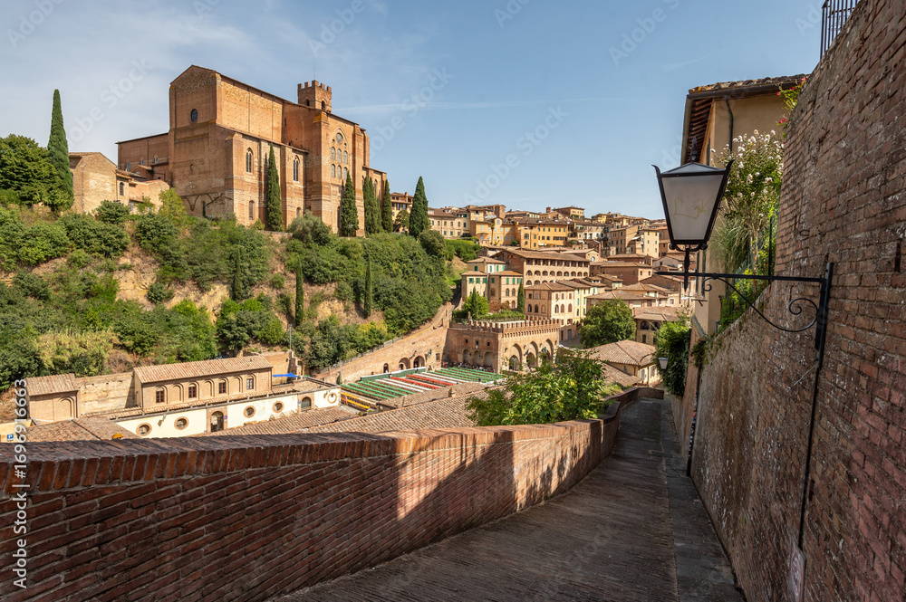 Naklejka premium Beautiful Tuscan historical street and place in the city of Siena, Tuscany, Italy, Europe. Medieval atmosphere, Gate