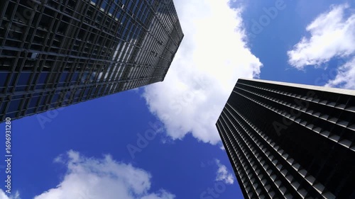 china - shenzhen - 2 wolkenkratzer mit vorbeiziehenden wolken am tag unter blauem himmel - zeitraffer