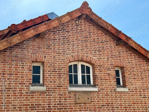 view of the facade of a red brick Sologne house on a sunny summer day with a blue sky in the background
