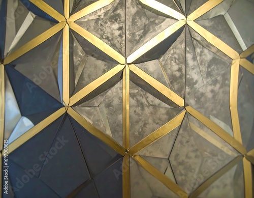 A geometric design featuring interlocking triangles of various shades of gray and accented with golden lines creates a captivating visual effect.