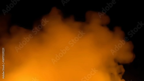 Thick, fiery orange and yellow smoke billows against a solid black background. This professional shot captures the intensity of fire and heat, making it perfect for creative and abstract projects.