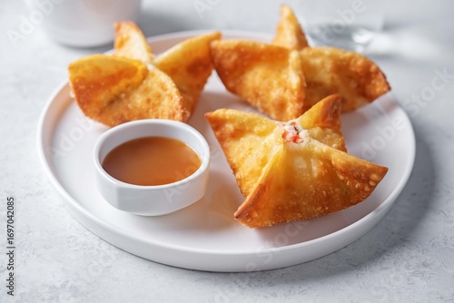 Crab rangoon with sauce in a plate