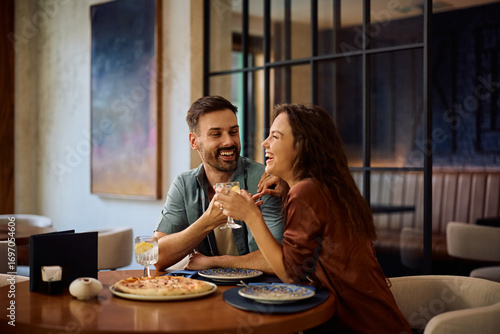 Fotografie Young couple laughing and having fun during a lunch in pizzeria.