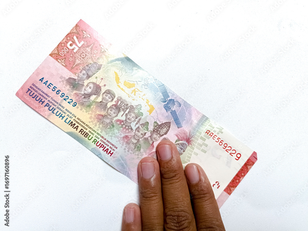 Obraz premium Broken and dirty Rupiah paper money on a white background. Conceptual photo of old dirty crumpled Indonesian Rupiah, illustrating criminal money, dirty money. Crumpled wrinkled money paper. Rp 75000