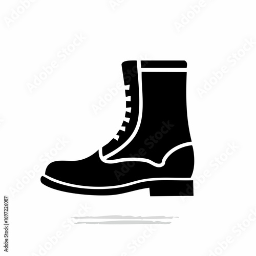 Black boot stands on white surface, showcasing its laces and sturdy sole with a simple, minimalist aesthetic.